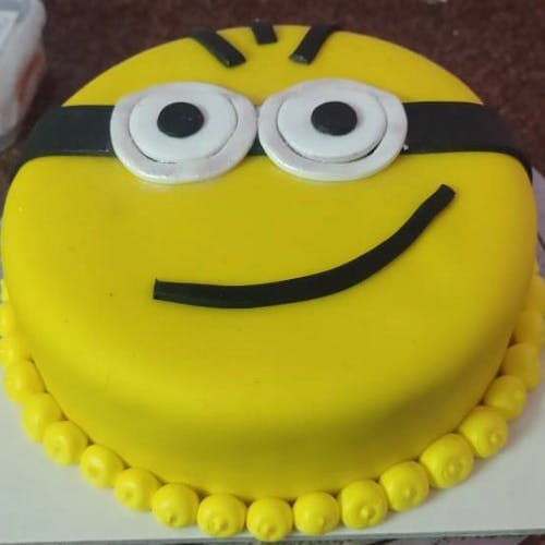 Minion Fondant Cake Bring a touch of whimsy and childlike joy to your next celebration with our Minion Fondant Cake, a playful masterpiece that captures the essence of fun and adventure.